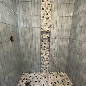Solace Showers - a tiled shower with black and white pebbles - General Contractors Near Me - Clayton, North Carolina Solace Showers - a tiled shower with black and white pebbles - General Contractors Near Me - Clayton, North Carolina
