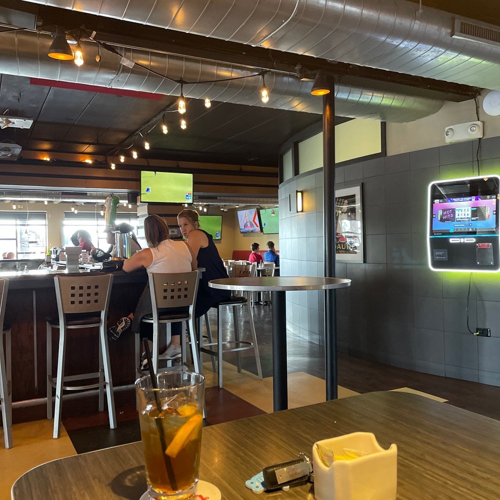 a view of a bar with people sitting at the bar a view of a bar with people sitting at the bar
