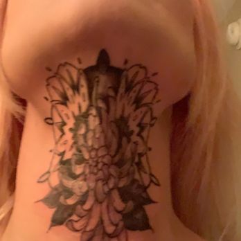 Moth Studio - Chrysanthemum neck tattoo done by Steffie - A person with pink hair and makeup has a tattoo on their neck, seen from a low angle, with their face tilted upward. - Tattoo Near Me - Springfield, Missouri