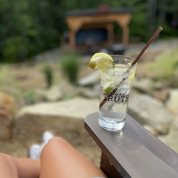 Hard Truth Distilling - a woman sitting on a bench with a drink - Distilleries Near Me - Nashville, Indiana Hard Truth Distilling - a woman sitting on a bench with a drink - Distilleries Near Me - Nashville, Indiana