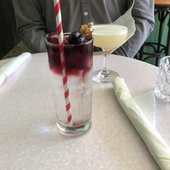 Bar Habana - a man sitting at a table with a drink and a cocktail - Cuban Near Me - Toronto, Ontario Bar Habana - a man sitting at a table with a drink and a cocktail - Cuban Near Me - Toronto, Ontario