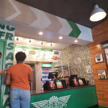 Wingstop - a woman standing in front of the counter - Chicken Wings Near Me - Bronx, New York