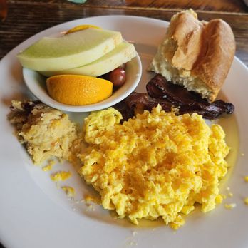 Crockett's 1875 Breakfast Camp - Hen Fruit (Eggs) w/ pecan-smoked bacon, biscuit, scrambled eggs w/ cheddar cheese, Cherokee sweet corn pone, fresh fruit - Breakfast & Brunch Near Me - Gatlinburg, Tennessee Crockett's 1875 Breakfast Camp - Hen Fruit (Eggs) w/ pecan-smoked bacon, biscuit, scrambled eggs w/ cheddar cheese, Cherokee sweet corn pone, fresh fruit - Breakfast & Brunch Near Me - Gatlinburg, Tennessee