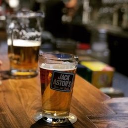 two glasses of beer on a bar
