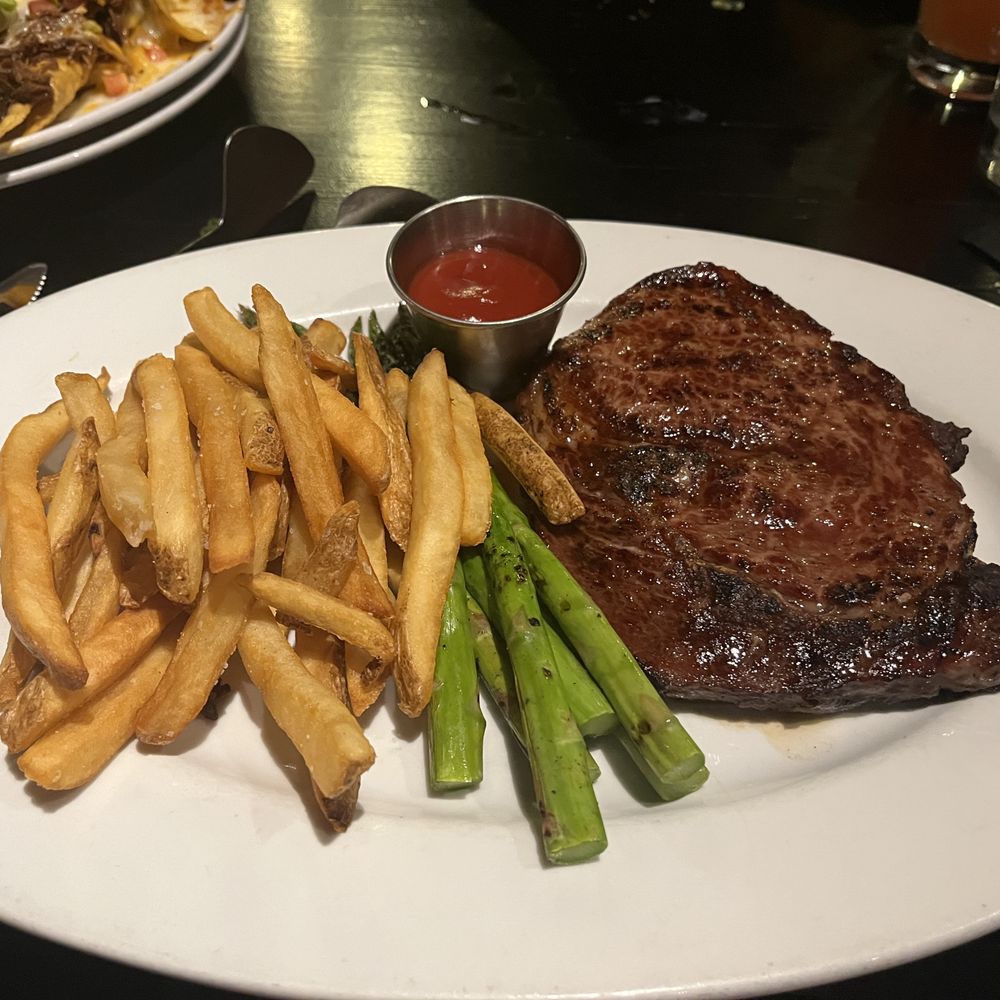 Grill 89 - Boneless Ribeye 12oz; with fries and asparagus - New American Near Me - Westmont, Illinois