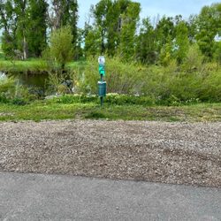 Steamboat Springs KOA - Island dogs waste station with over grown grass.
