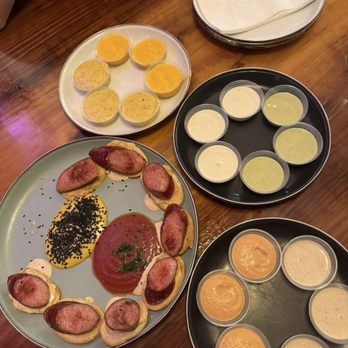 Gunsmoke BBQ - Kielbasa Morsels $19.50 smoked/reverse seared kielbasa, "top tomato" sauce, "truffle mustard" sauce, "bala" sauce, black sesame seeds - Barbeque Near Me - Santa Paula, California Gunsmoke BBQ - Kielbasa Morsels $19.50 smoked/reverse seared kielbasa, "top tomato" sauce, "truffle mustard" sauce, "bala" sauce, black sesame seeds - Barbeque Near Me - Santa Paula, California