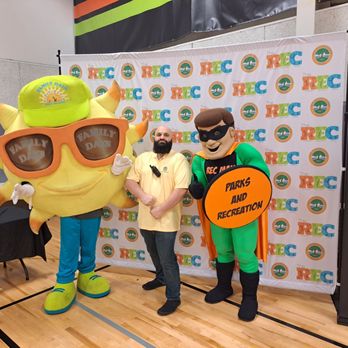 The REC - RECMAN our mascot for Parks and REC with Shades the Mascot for Port Orange Community Trust smiling for a photo at Grand Opening. - Recreation Centers Near Me - Port Orange, Florida