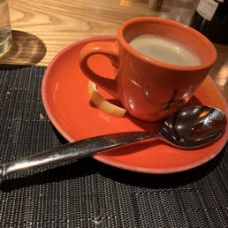 a cup of coffee on a saucer with a spoon