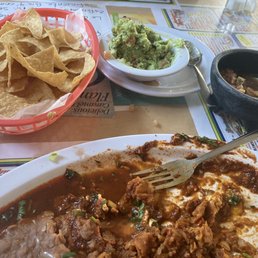 What's left of my Chilaquiles rojo con arroz y frijol; chips, salsa, and guacamole. What's left of my Chilaquiles rojo con arroz y frijol; chips, salsa, and guacamole.