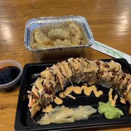 a plate of sushi and a container of sauce a plate of sushi and a container of sauce