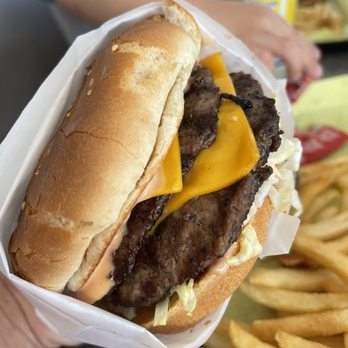 Dino's Burgers - a hand holding a cheeseburger - Burgers Near Me - Santa Ana, California