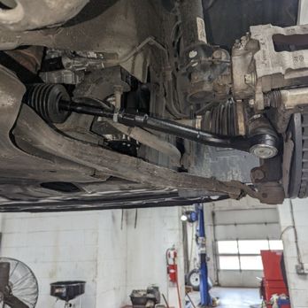 Tires Plus - Unfinished tie rod - The image depicts the underside of a vehicle in a repair shop, focusing on a tie rod that appears to be unfinished or in the process of repair. - Tires Near Me - Onalaska, Wisconsin