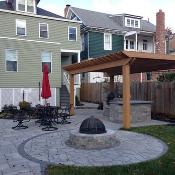 American Deck and Patio - A NWDC row home backyard entertaining area complete with custom cedar pergola over outdoor kitchen area, fire pit area, and outdoor dining. - Patio Coverings Near Me - Bethesda, Maryland