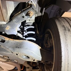 Indy Auto Man - Right rear tire damage, heavy corrosion, and suspension element damage.