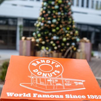 Randy's Donuts - a person holding a box of doughnuts - Donuts Near Me - Pasadena, California