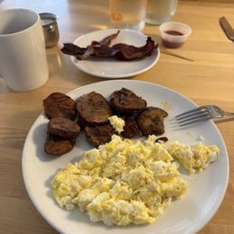 Scrambled eggs, potatoes and crispy bacon with coffee. Scrambled eggs, potatoes and crispy bacon with coffee.
