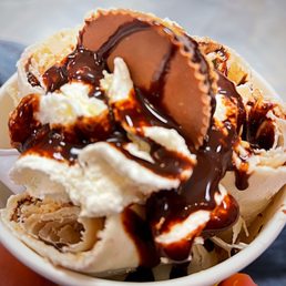 a hand holding a bowl of ice cream