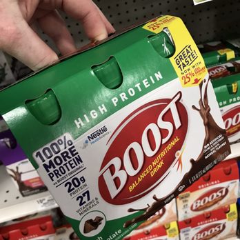 Giant Eagle - Boost protein drink - A person’s hand is gripping a box of Boost high protein nutritional drink on store shelves, with other Boost products visible in the background. - Grocery Near Me - Heath, Ohio