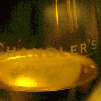 Chandler's - Wine glass in candlelight - New American Near Me - Petoskey, Michigan