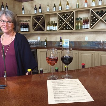 Rockwall Cellars - a woman behind a bar with wine glasses - Wineries Near Me - Omak, Washington Rockwall Cellars - a woman behind a bar with wine glasses - Wineries Near Me - Omak, Washington