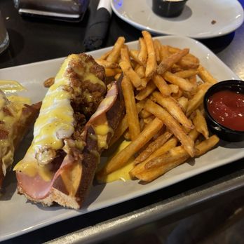 Over/Under - Pretzel cordon bleu with fries with leftover southwest egg roll on other plate. - Sports Bars Near Me - Paducah, Kentucky