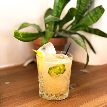 Moniker Cocktail Co - a glass filled with a drink and garnished with a slice of cucumber - Cocktail Bars Near Me - San Diego, California Moniker Cocktail Co - a glass filled with a drink and garnished with a slice of cucumber - Cocktail Bars Near Me - San Diego, California