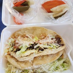 two trays of food on a bed