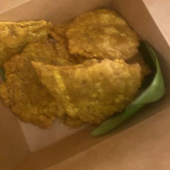Buen Provecho - Several pieces of fried chicken are placed in a cardboard takeout container with a green leaf lining, likely for serving or takeout. - Latin American Near Me - Albuquerque, New Mexico
