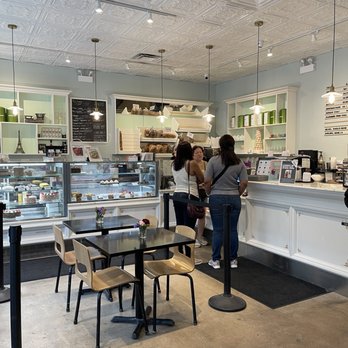 Verzenay - Interior - Inside a pastry shop, customers are placing orders at the counter, with display cases of baked goods and a menu board visible. - Desserts Near Me - Chicago, Illinois