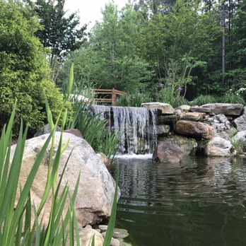 Ponders - a waterfall flowing over rocks in a pond - Landscaping Near Me - Harrisburg, North Carolina Ponders - a waterfall flowing over rocks in a pond - Landscaping Near Me - Harrisburg, North Carolina
