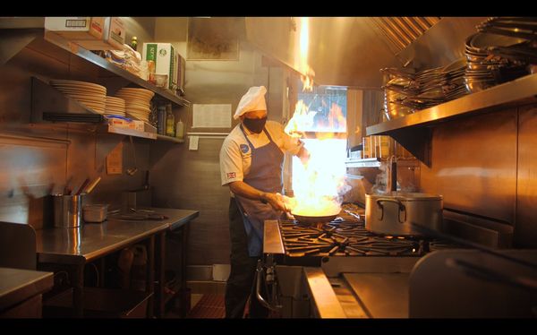 Photo of Luna Blu - Tiburon, CA, US. Executive Chef Renzo Azzarello creating culinary magic at the same time wearing a face mask due to the pandemic.