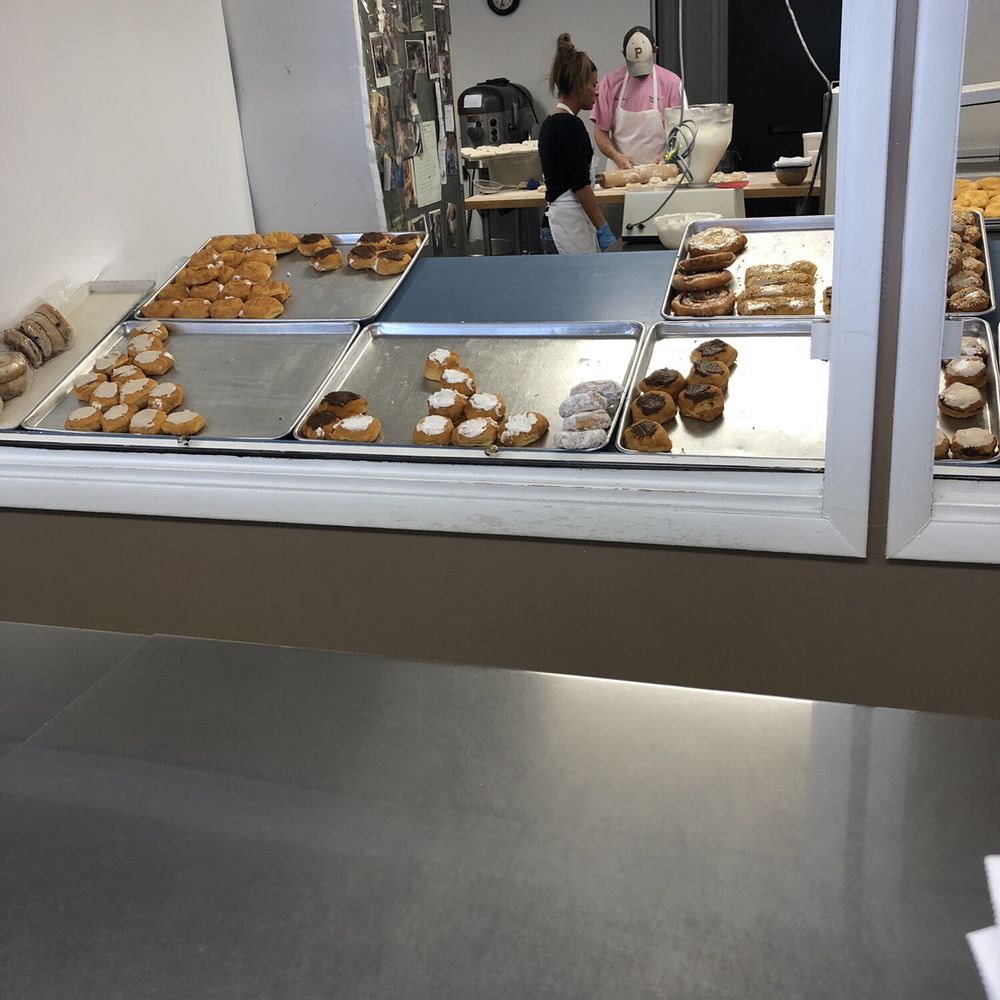 a woman working in a donut shop a woman working in a donut shop