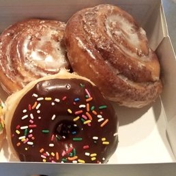 Cinnamon roll donuts and glazed chocolate with sprinkles.