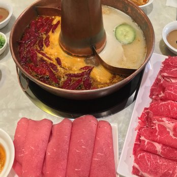 Beijing Hot Pot Restaurant - The spicy broth (left half) and pork bone broth (right half), surrounded by various sauces and yet-to-be-cooked ingredients - Hot Pot Near Me - Toronto, Ontario Beijing Hot Pot Restaurant - The spicy broth (left half) and pork bone broth (right half), surrounded by various sauces and yet-to-be-cooked ingredients - Hot Pot Near Me - Toronto, Ontario