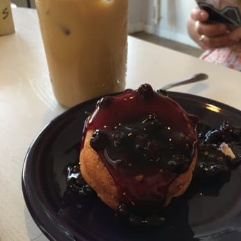 The Bean Coffee Shop - Blue bomb - dough covered with blueberry sauce. Iced coffee in the background - Desserts Near Me - Auburn, Alabama The Bean Coffee Shop - Blue bomb - dough covered with blueberry sauce. Iced coffee in the background - Desserts Near Me - Auburn, Alabama