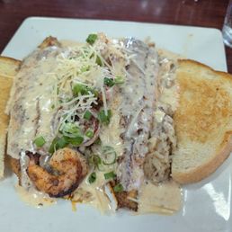 Catfish Mardi Gras - A dish featuring catfish covered in gravy, served with rice and toasted bread at Cormier’s Kitchen in Spring, TX.