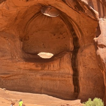 Sacred Monument Tours - Shallow cave was used in the Indiana Jones movie snake pit scene. The top has a round hole that the light is shining through. - Tours Near Me - Monument Valley, Arizona Sacred Monument Tours - Shallow cave was used in the Indiana Jones movie snake pit scene. The top has a round hole that the light is shining through. - Tours Near Me - Monument Valley, Arizona