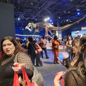 Orlando Science Center - Dressed up guests amidst the dinosaurs. - Museums Near Me - Orlando, Florida