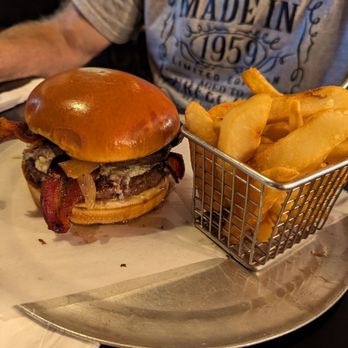 Burgers & Beer - a man sitting at a table with a basket of fries - Burgers Near Me - Bradley, Illinois