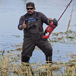 Our technician removing excess vegetation and debris -- keeping ponds clean, clear, and balanced.
