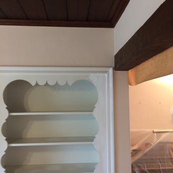 Quick Painting - Photo of display shelves during painting, first coat of two. Also note protection of piano. - Painters Near Me