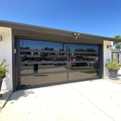 From Steel to Style: Black Glass Upgrade - Originally this home had a standard 16x7 long panel steel garage door — functional, but dated in appearance. We upgraded it to a stunning 16x7 black glass garage door, creating a sleek, modern look that completely transformed the front of the home. The new door not only enhances curb appeal but also adds a touch of elegance and contemporary style From Steel to Style: Black Glass Upgrade - Originally this home had a standard 16x7 long panel steel garage door — functional, but dated in appearance. We upgraded it to a stunning 16x7 black glass garage door, creating a sleek, modern look that completely transformed the front of the home. The new door not only enhances curb appeal but also adds a touch of elegance and contemporary style