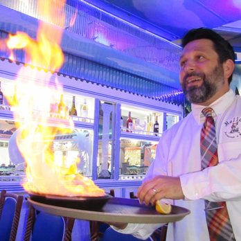 Hellas Restaurant - Jimmy, our server, with the flaming cheese Saganaki. OPA! - Bakeries Near Me - Tarpon Springs, Florida
