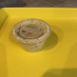 Queso in a small condiment size container. Queso in a small condiment size container.