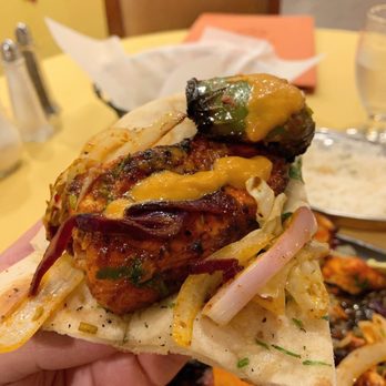 Aroma - a hand holding a sandwich with meat and vegetables - Indian Near Me - Galloway, New Jersey Aroma - a hand holding a sandwich with meat and vegetables - Indian Near Me - Galloway, New Jersey