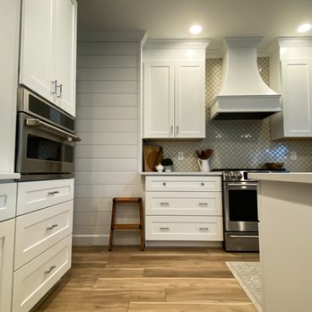 Affordable Interiors - a kitchen with white cabinets and wood floors - Countertop Installation Near Me - Tacoma, Washington Affordable Interiors - a kitchen with white cabinets and wood floors - Countertop Installation Near Me - Tacoma, Washington