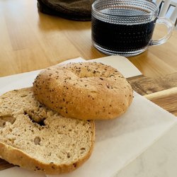 Whole wheat everything bagel with steaming hot coffee.