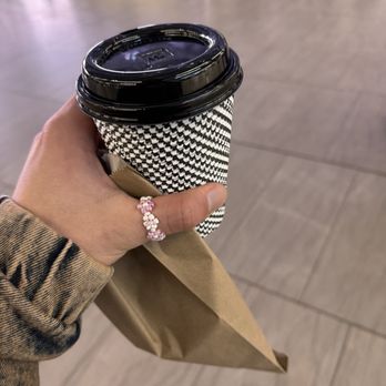 Vesuvio Bakery - Moynihan Train Hall - a hand holding a coffee cup - Bakeries Near Me - New York, New York Vesuvio Bakery - Moynihan Train Hall - a hand holding a coffee cup - Bakeries Near Me - New York, New York