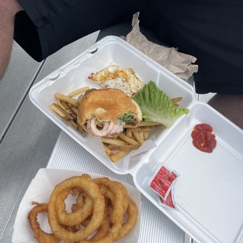 Shipwreck'd - Side of beer battered onion rings and Booster Burger Plate sooo good!service was great and quick! - A meal includes fried onion rings, a burger with fries, and a fried egg on a tray, with ketchup and a small condiment packet. - Breakfast & Brunch Near Me - Hull, Massachusetts